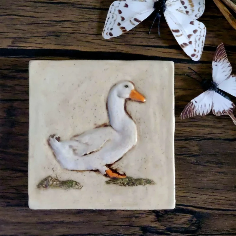 white duck ceramic art tile 4 inch by 4 inch shown with butterfly props.