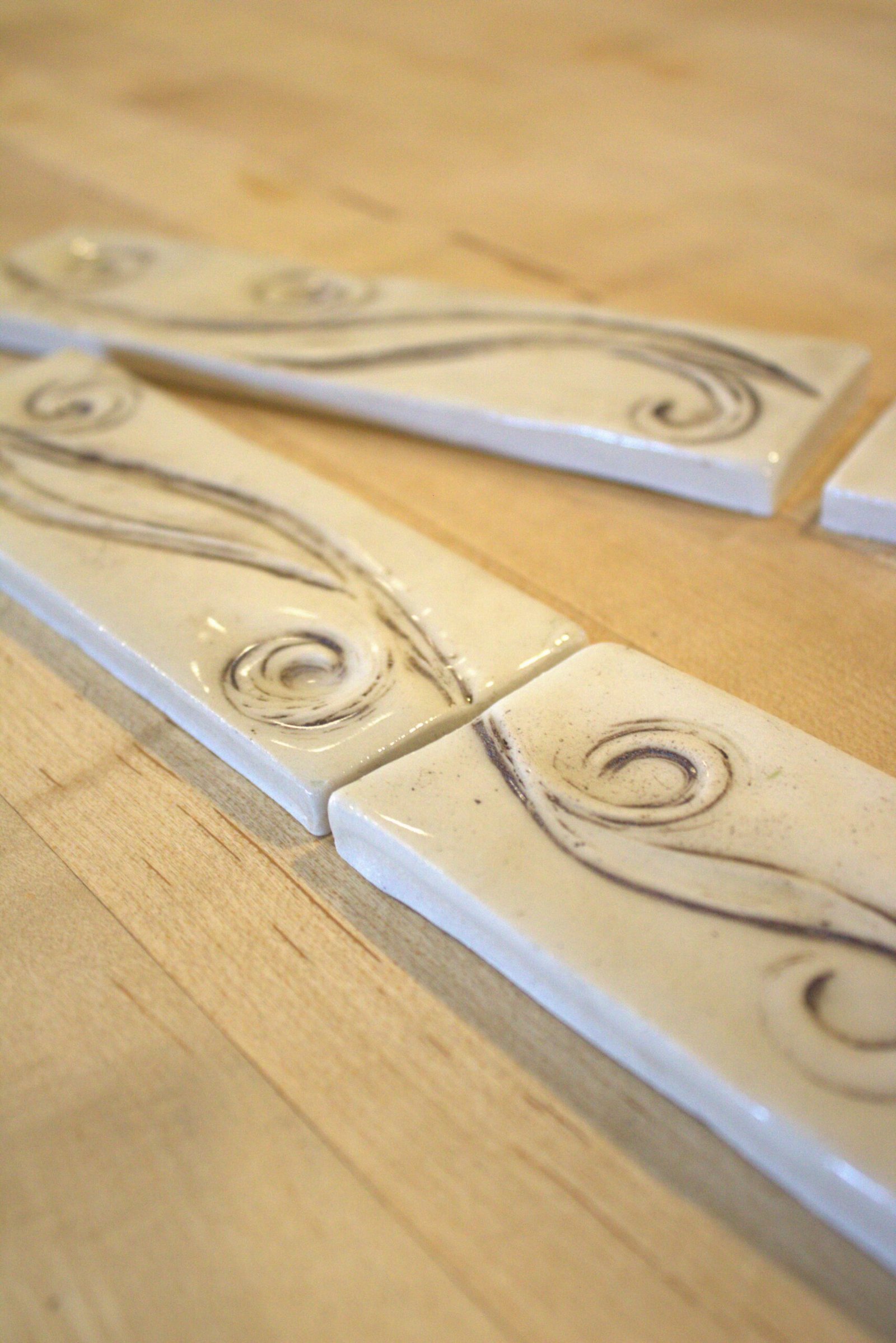 Handcrafted ceramic border tile with a flowing meadow breeze design inspired by the gentle movement of a Wyoming Mountain Breeze