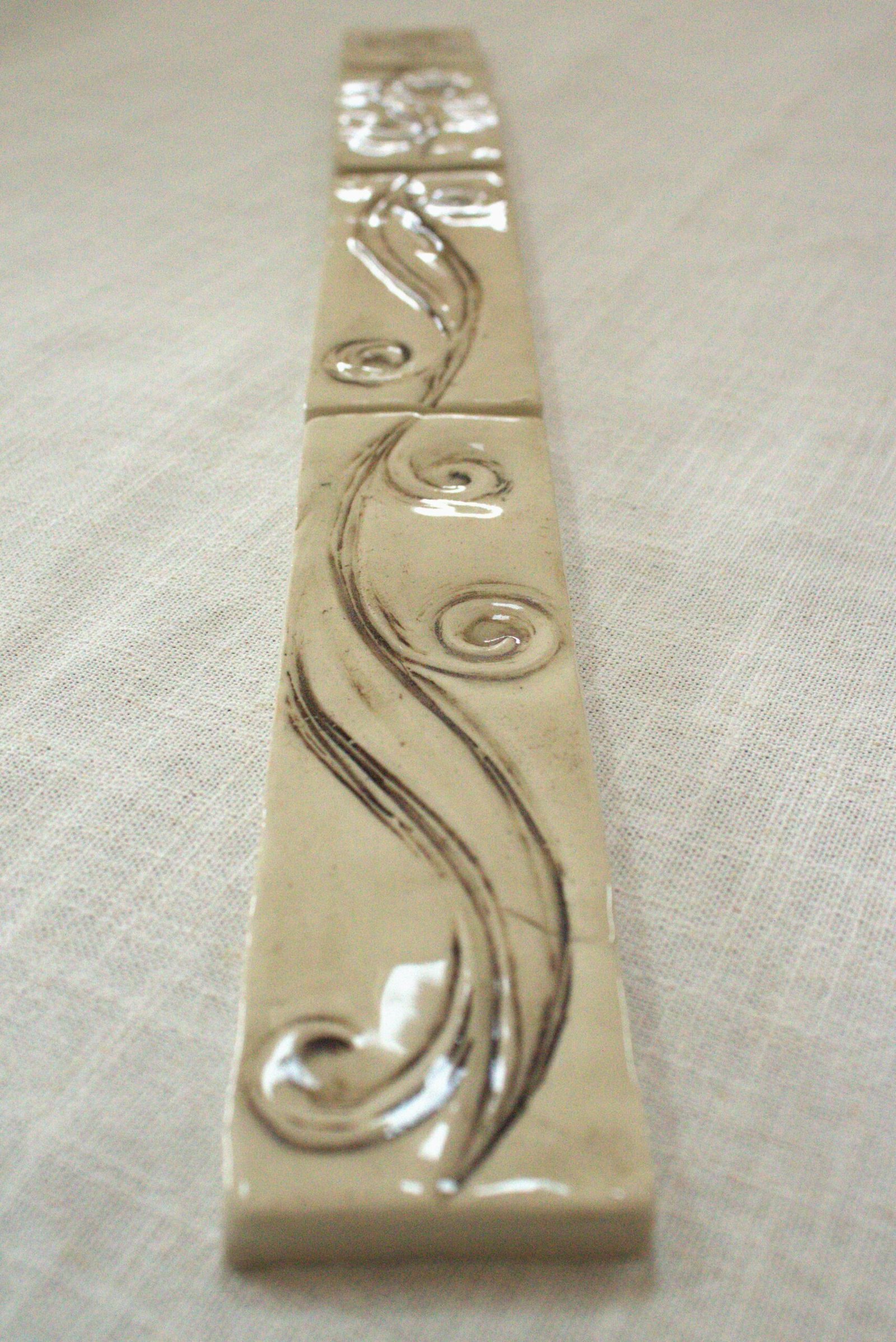 Meadow Breeze border tiles lined up to show detail of carving