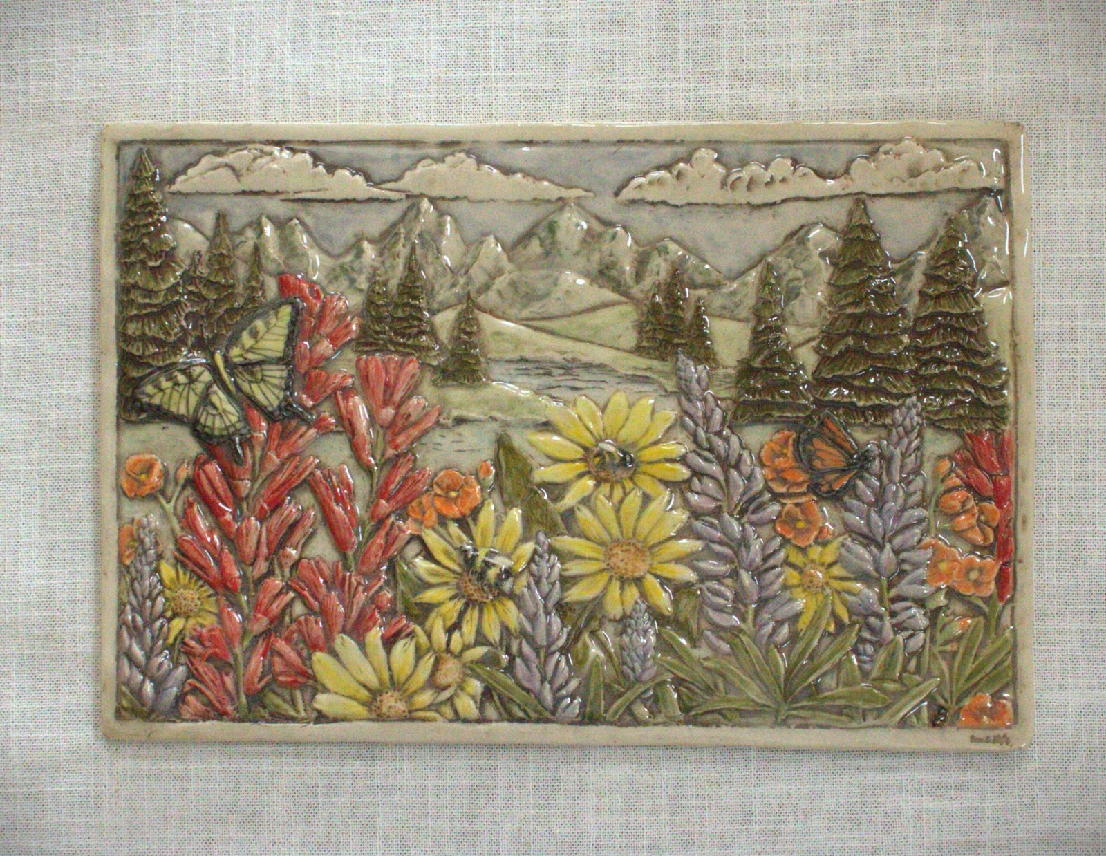 Handcrafted ceramic art tile featuring Wyoming wildflowers including Paintbrush, Lupin, and Arrow Leaf Balsamrootwith native bees and butterflies